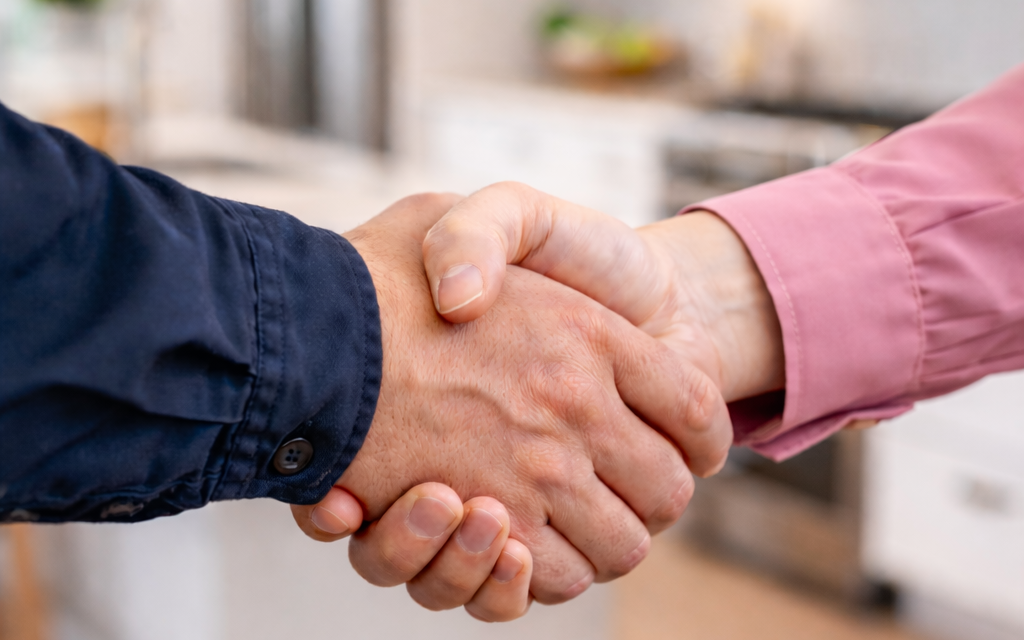 Handshake between a man and a woman in a modern renovated home